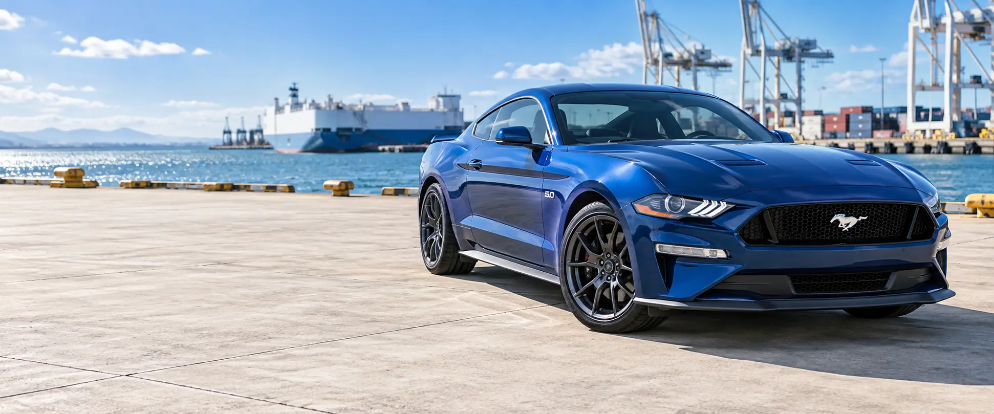 Niebieski Ford Mustang w słonecznym porcie